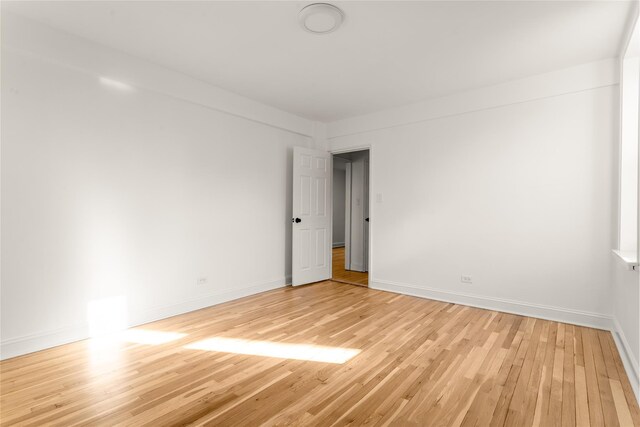 empty room with light wood-style flooring and baseboards