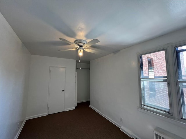 142 Garth Rd Unit 1P, Scarsdale, NY 10583 - unfurnished bedroom featuring a closet, baseboards, dark carpet, and ceiling fan