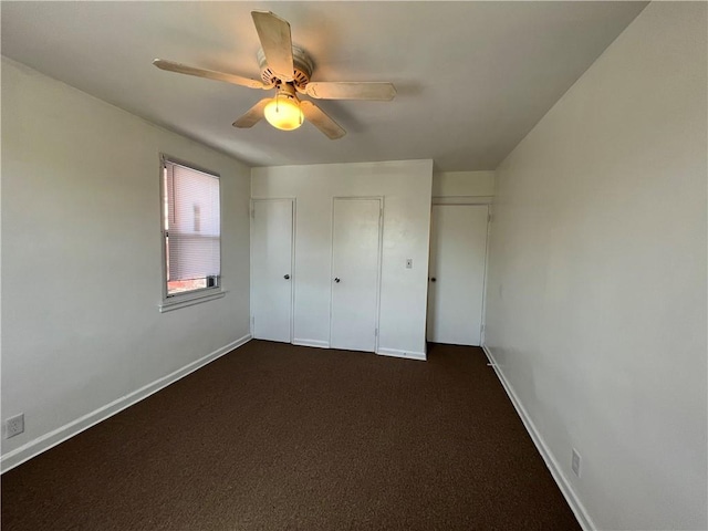 142 Garth Rd Unit 1P, Scarsdale, NY 10583 - unfurnished bedroom with ceiling fan, baseboards, dark carpet, and two closets
