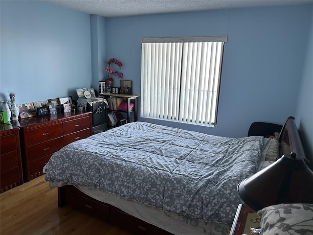 bedroom featuring a textured ceiling and wood finished floors