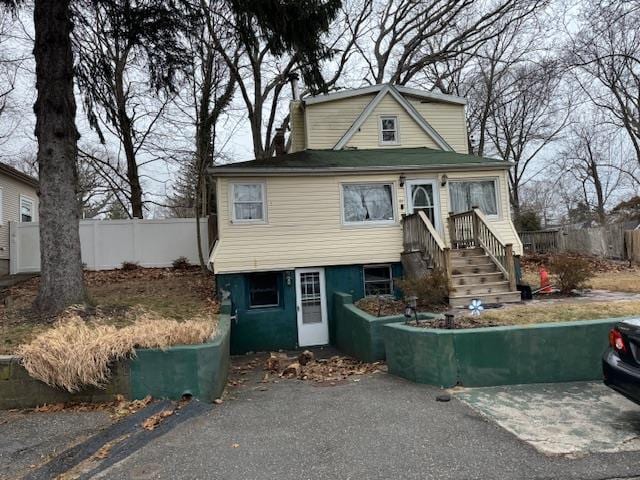 view of front facade with driveway and fence