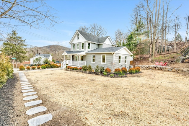 view of front of house featuring a porch, roof with shingles, and driveway