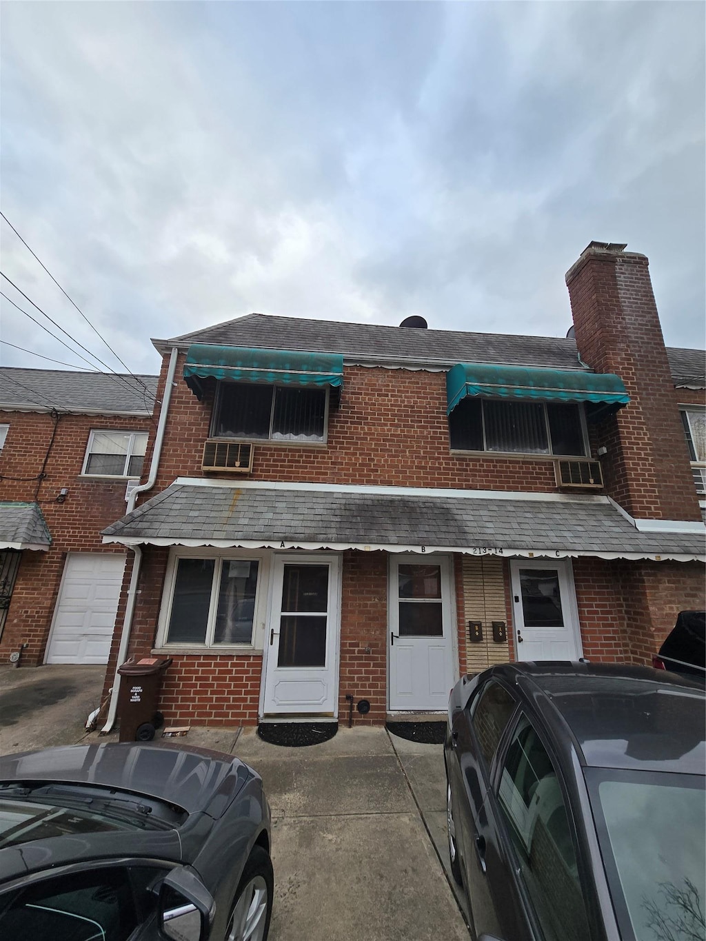 townhome / multi-family property with a garage, concrete driveway, and brick siding