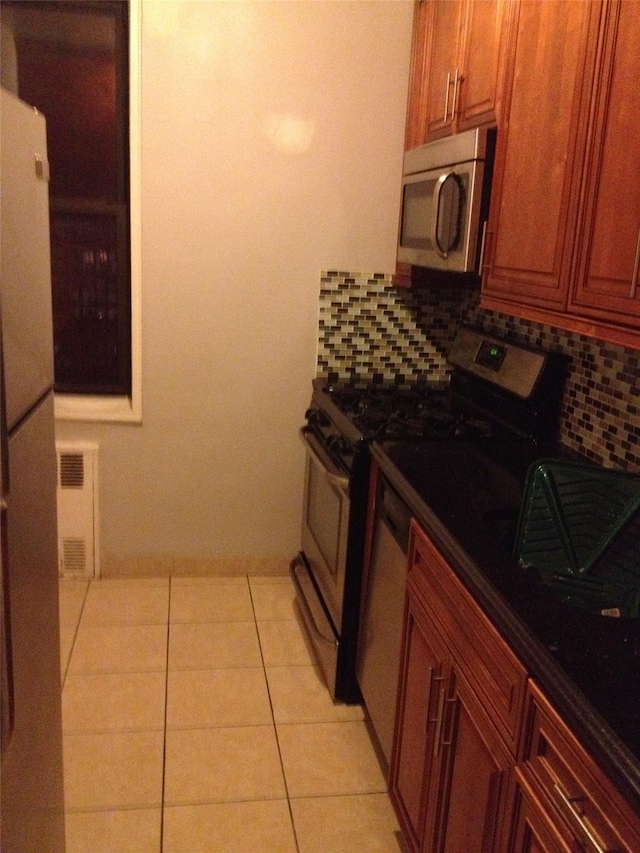 kitchen with appliances with stainless steel finishes, brown cabinets, visible vents, and decorative backsplash