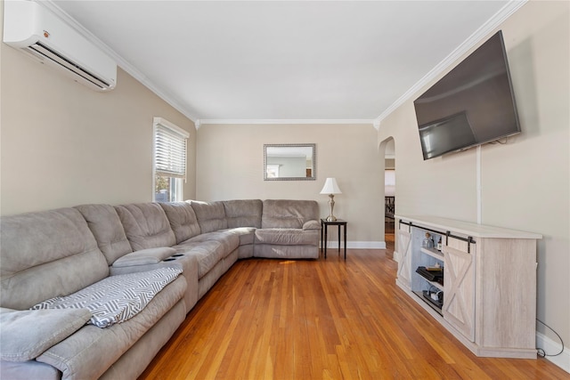 living area featuring an AC wall unit, light wood-type flooring, and crown molding