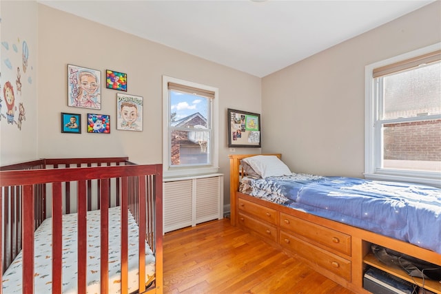 bedroom featuring multiple windows and light wood-type flooring