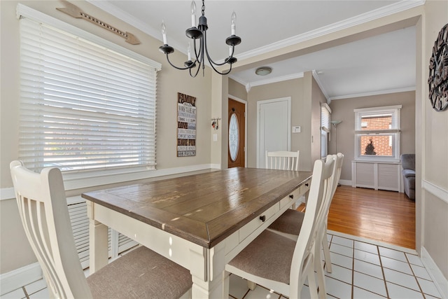 dining space with a chandelier, light tile patterned flooring, crown molding, and baseboards