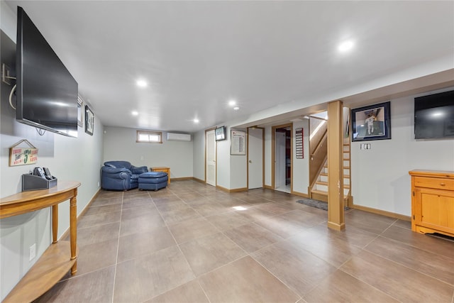 basement with stairs, an AC wall unit, baseboards, and recessed lighting