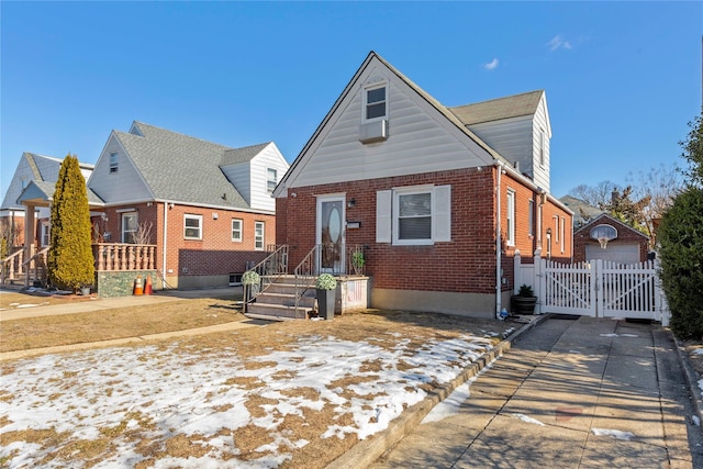 view of front facade with brick siding, fence, and a gate