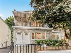 view of front of home featuring a fenced front yard, a gate, and a balcony