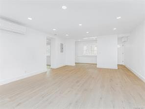 empty room featuring light wood-type flooring, baseboards, and recessed lighting