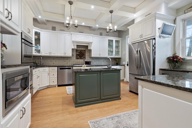 kitchen with a center island with sink, white cabinetry, and stainless steel appliances