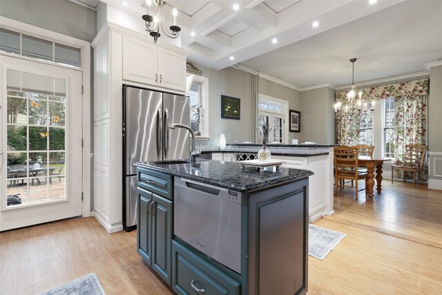 kitchen featuring light wood finished floors, white cabinets, coffered ceiling, and an island with sink