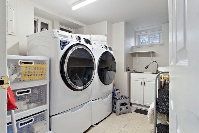 clothes washing area with washer and dryer, light tile patterned flooring, cabinet space, and a sink