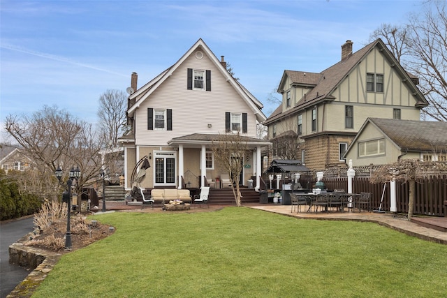 back of house featuring a patio area, a chimney, a yard, and fence