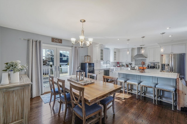 dining space featuring an inviting chandelier, recessed lighting, french doors, and dark wood-style flooring