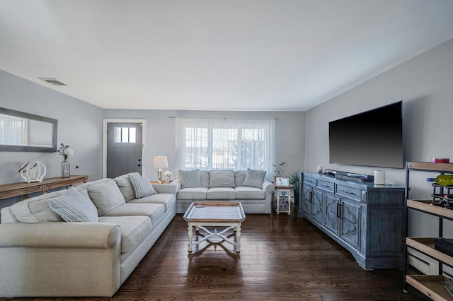 living area featuring visible vents and dark wood-style floors