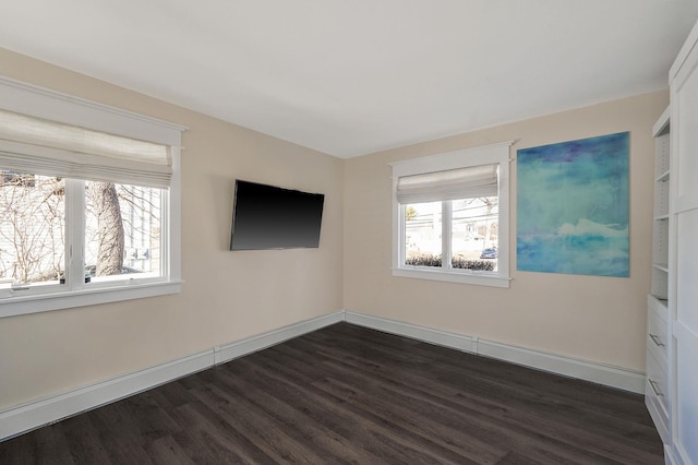 unfurnished room featuring baseboards, a healthy amount of sunlight, and dark wood-style floors