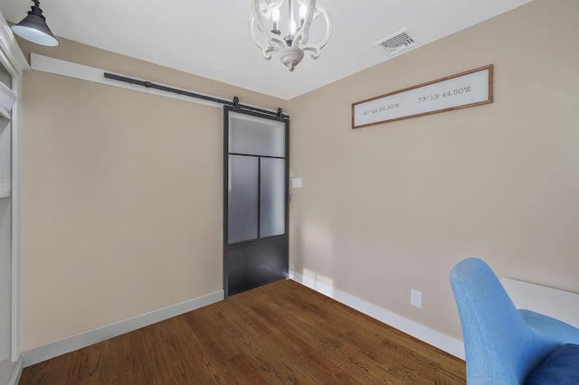 unfurnished office featuring visible vents, baseboards, a barn door, a notable chandelier, and dark wood-style flooring