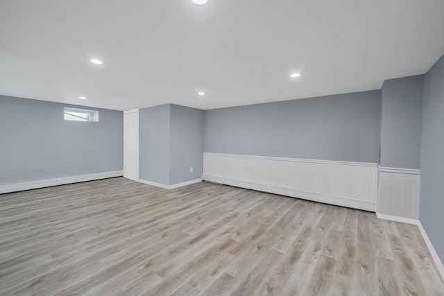 below grade area with recessed lighting, wainscoting, and wood finished floors