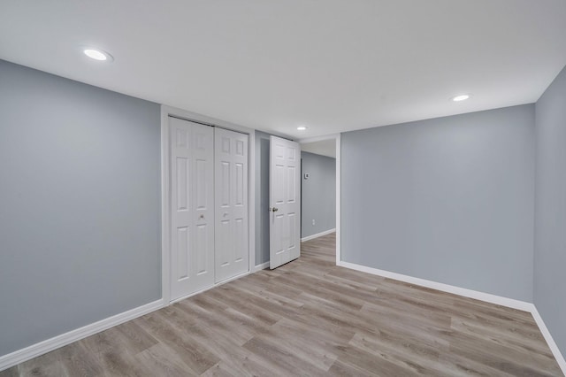 unfurnished bedroom featuring recessed lighting, baseboards, a closet, and light wood-type flooring