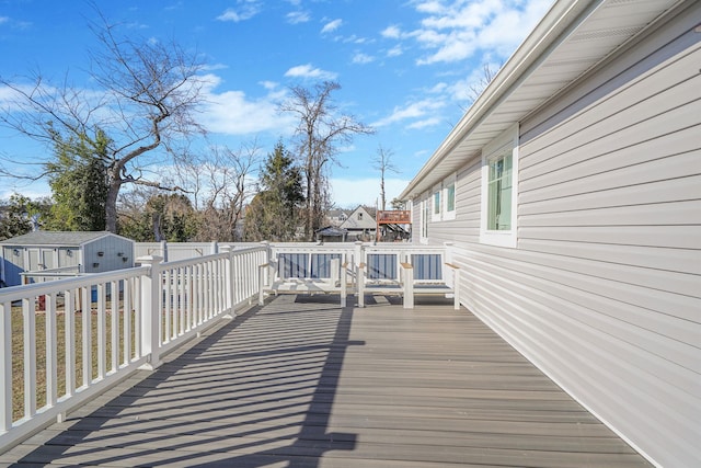 deck with an outbuilding, a fenced backyard, and a shed