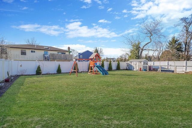 view of yard with an outbuilding, a playground, and a fenced backyard