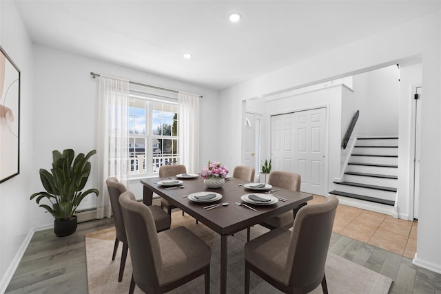 dining space with a baseboard heating unit, stairway, wood finished floors, and recessed lighting