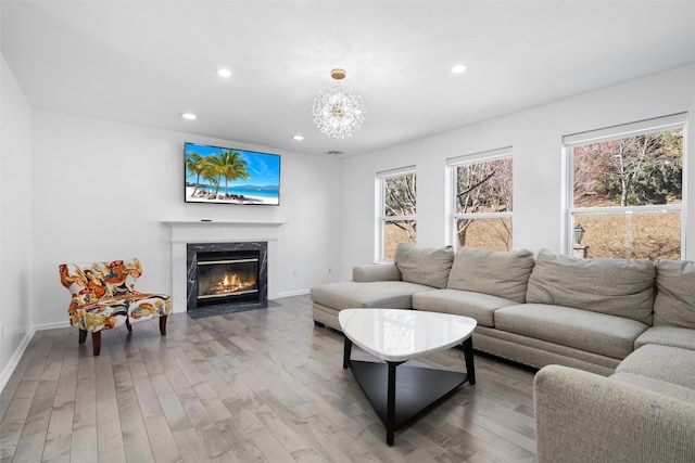 living area with a fireplace, a chandelier, wood finished floors, and recessed lighting