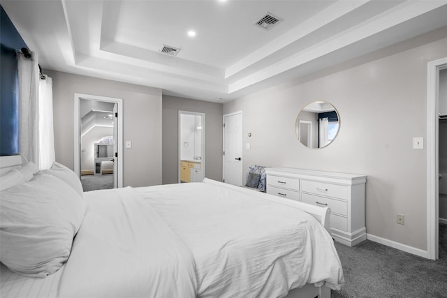 bedroom featuring dark carpet, a raised ceiling, visible vents, and baseboards