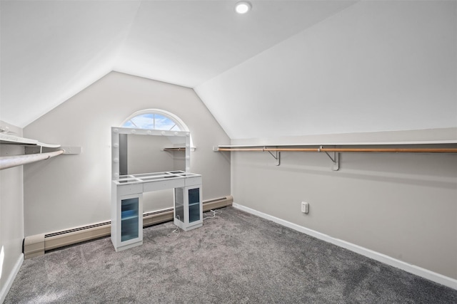 walk in closet with vaulted ceiling, a baseboard radiator, and carpet flooring