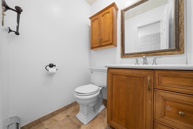 half bathroom featuring tile patterned floors, vanity, toilet, and baseboards