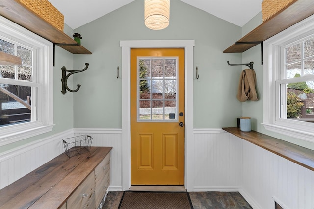 mudroom with a wainscoted wall, lofted ceiling, and a healthy amount of sunlight