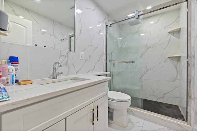 bathroom featuring marble finish floor, toilet, vanity, and a marble finish shower