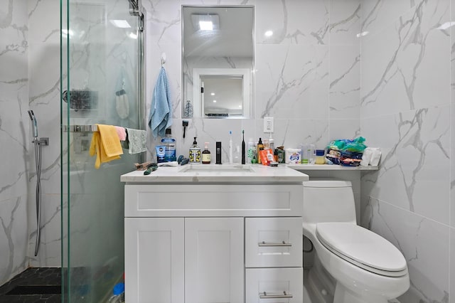 bathroom featuring tile walls, toilet, vanity, and a marble finish shower