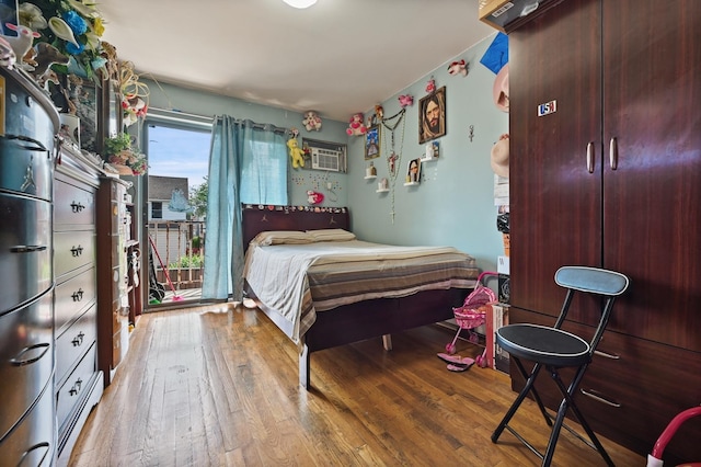 bedroom with wood-type flooring and a wall mounted air conditioner