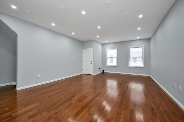 empty room featuring baseboards, dark wood-style flooring, and recessed lighting