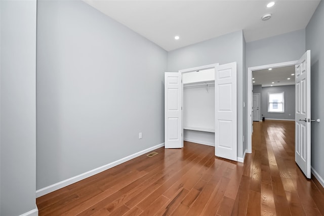 unfurnished bedroom featuring recessed lighting, wood-type flooring, visible vents, and baseboards