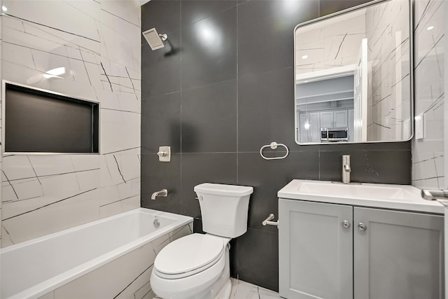 bathroom featuring tasteful backsplash, vanity, toilet, and tile walls