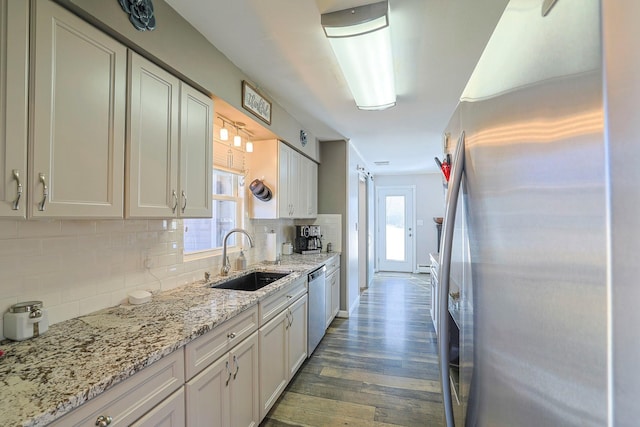 kitchen with a sink, decorative backsplash, a wealth of natural light, and stainless steel appliances