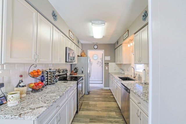 kitchen featuring a sink, light wood-style floors, appliances with stainless steel finishes, and white cabinets