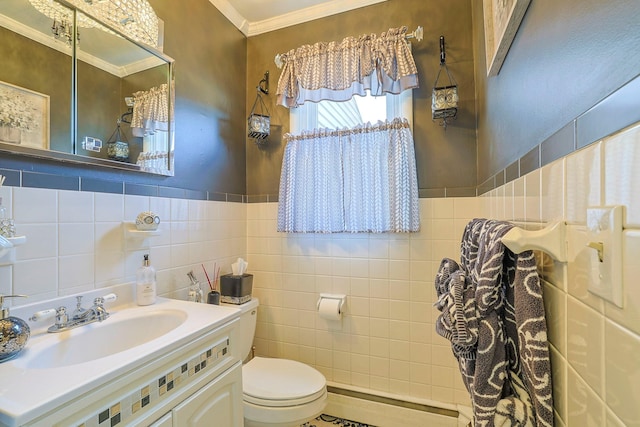 half bath with vanity, ornamental molding, wainscoting, tile walls, and toilet