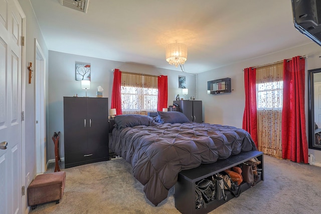 carpeted bedroom featuring visible vents and a chandelier