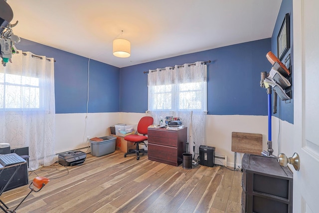 office featuring a baseboard heating unit and wood finished floors