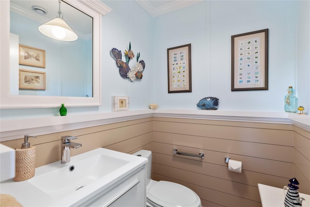 bathroom featuring ornamental molding, vanity, and toilet