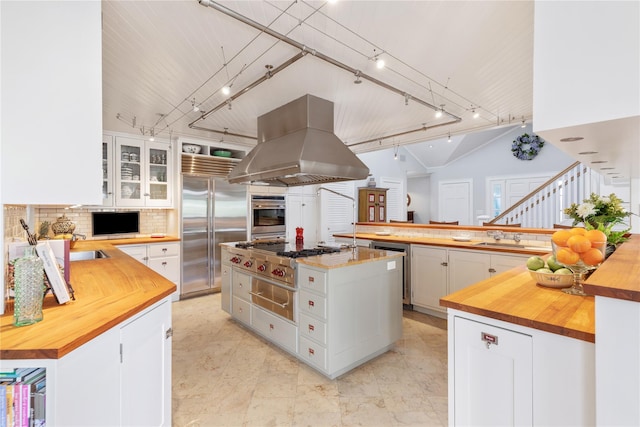 kitchen with stainless steel appliances, butcher block counters, a large island, and island range hood