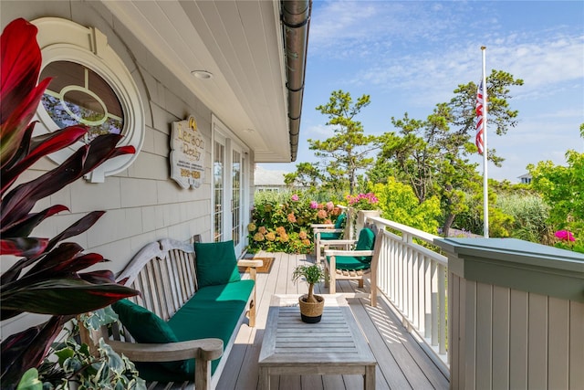 view of wooden balcony with a deck, an outdoor hangout area, and french doors