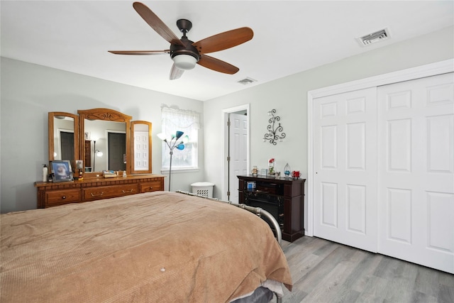 bedroom with a closet, visible vents, a ceiling fan, and light wood-style floors