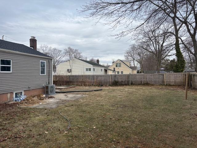 view of yard with a fenced backyard and central air condition unit