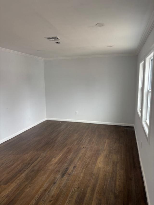 unfurnished room featuring dark wood-style floors, ornamental molding, visible vents, and baseboards